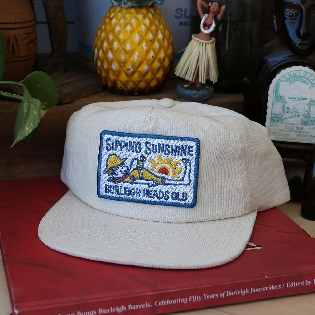 White corduroy cap hat sipping sunshine retro vintage surf cocktail tiki bar sunset